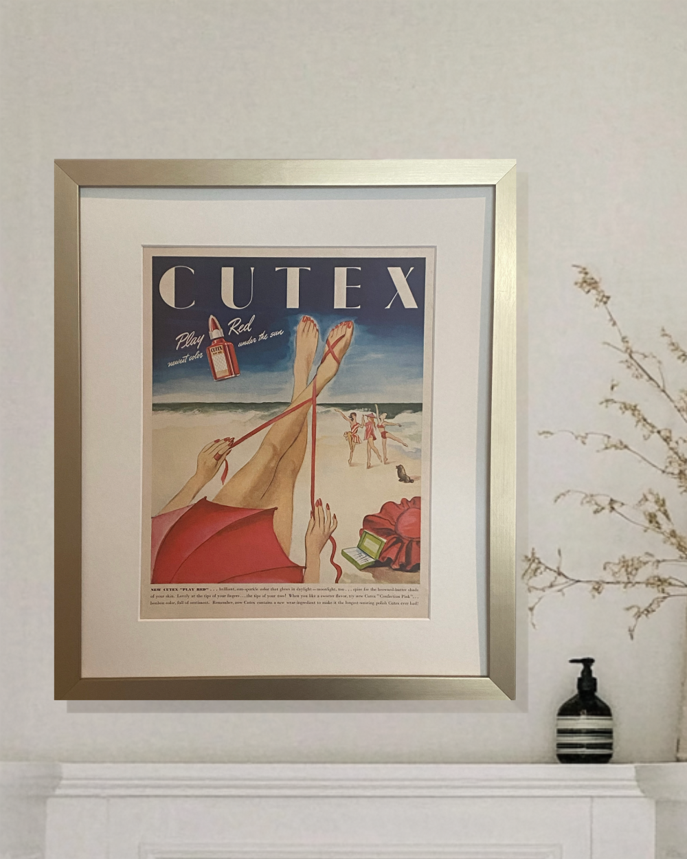 Original 1946 Cutex Play Red magazine advertisement in a brushed brass frame styled in a neutral bathroom