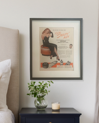 Framed original 1946 Mennen “I Like Smooth Men” advertisement styled above a nightstand in a neutral bedroom