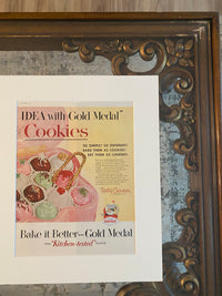 Close-up detail of brown wood frame and archival matting on original Betty Crocker Cookies advertisement
