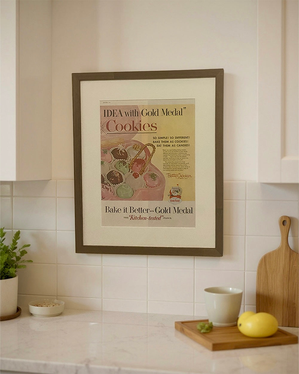 Original Betty Crocker Cookies vintage magazine advertisement displayed in a brown wood frame on a kitchen wall above a countertop