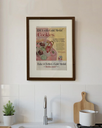 Original Betty Crocker Gold Medal Cookies vintage advertisement in a handcrafted walnut frame displayed above a modern kitchen countertop.