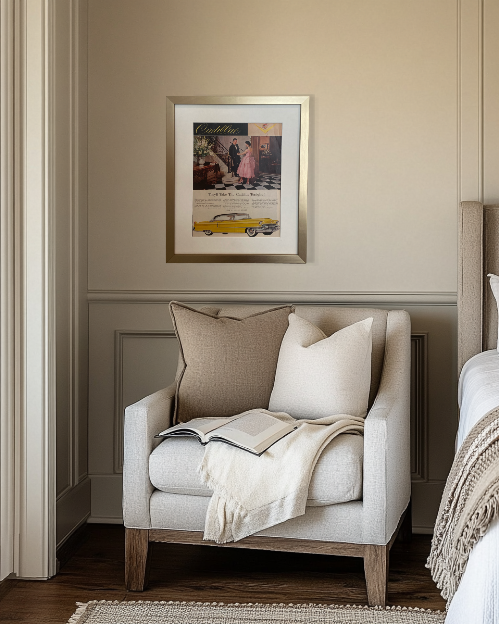 Original Cadillac vintage automobile advertisement in a brushed brass frame displayed above a neutral bedroom reading nook.