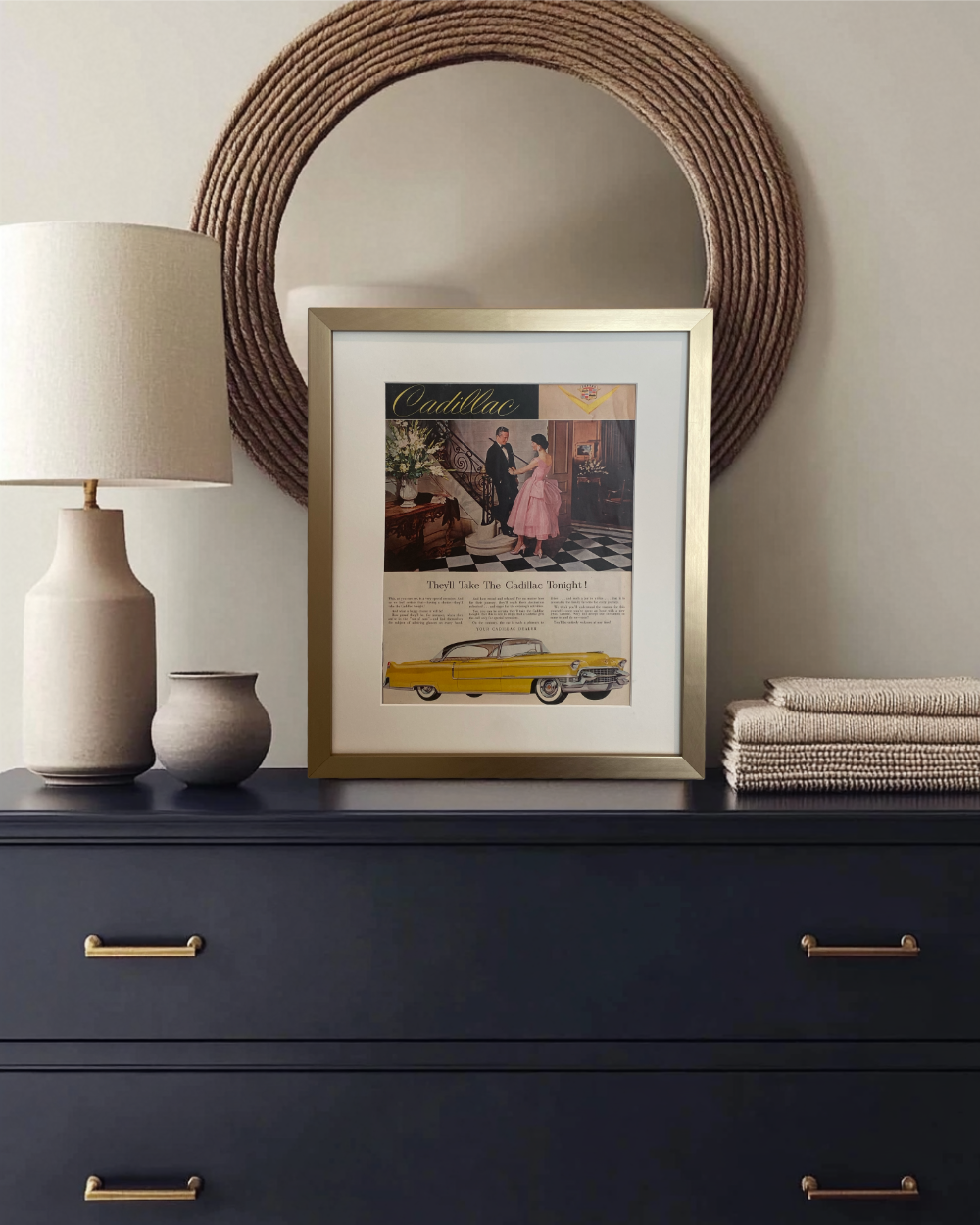 Original Cadillac vintage advertisement featuring a yellow Cadillac, beautifully framed in brushed brass and styled on a dark dresser with neutral accessories.