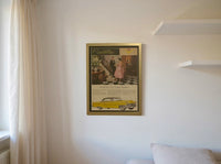 Original 1950s Cadillac magazine advertisement framed in gold, featuring an elegant couple and classic yellow Cadillac