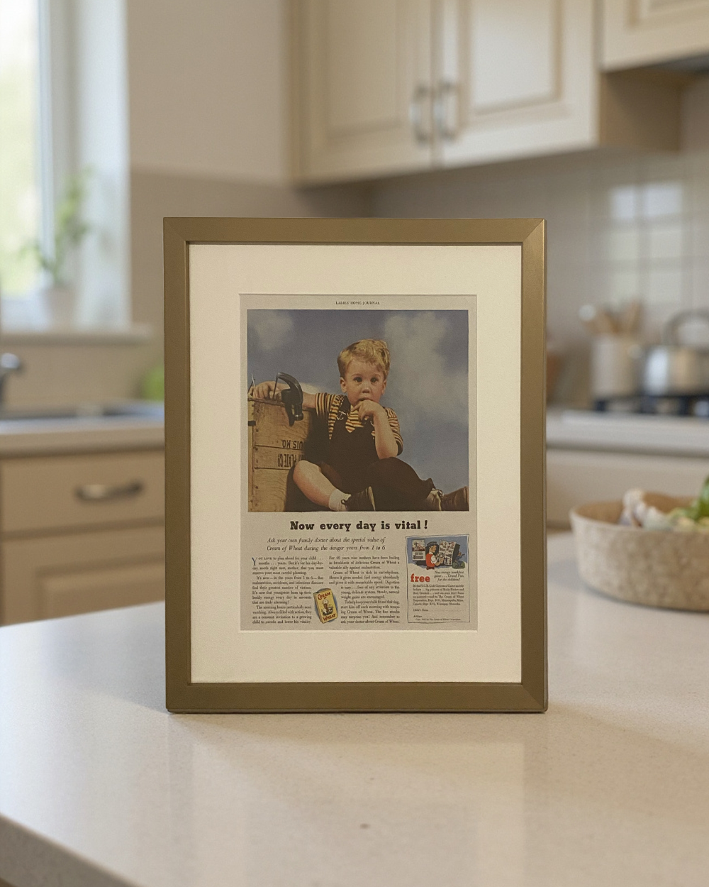 Original 1953 Cream of Wheat vintage advertisement in a toned brass frame displayed on a kitchen countertop with an off-white mat.
