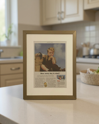 Original 1953 Cream of Wheat vintage advertisement in a toned brass frame displayed on a kitchen countertop with an off-white mat.