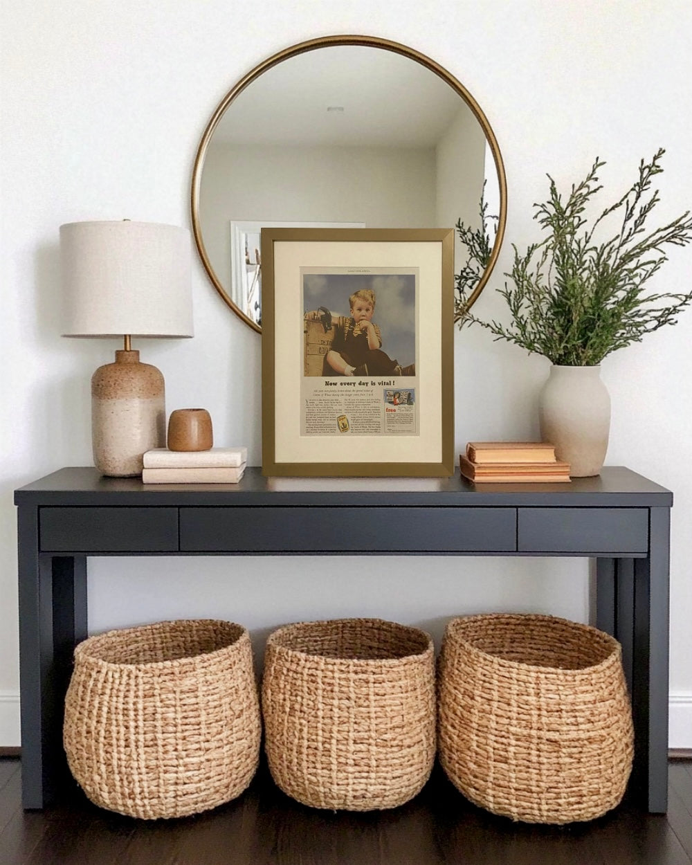 Original Cream of Wheat vintage advertisement in a brass frame styled on an entryway console beneath a round mirror.