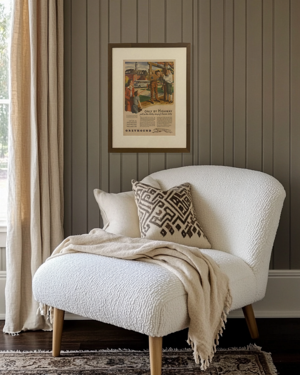 Framed original Greyhound “Only by Highway” vintage advertisement displayed above a sofa in a warm neutral living room.