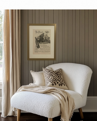 Original 1941 Hires Root Beer advertisement framed in brass and styled above a reading nook chair in a cozy modern home