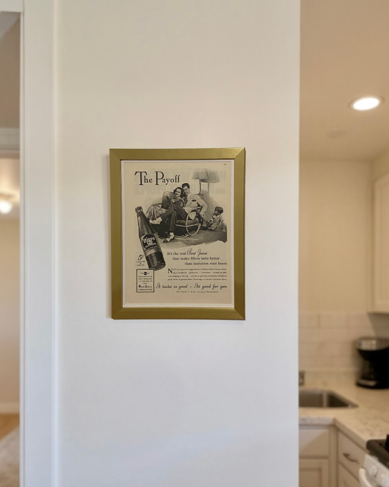 Framed 1941 Hires Root Beer “The Payoff” vintage advertisement displayed on a kitchen countertop.
