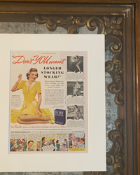 Original 1948 Ivory Flakes magazine advertisement displayed in a brass frame on a laundry room countertop beside a woven basket in a bright neutral interior.
