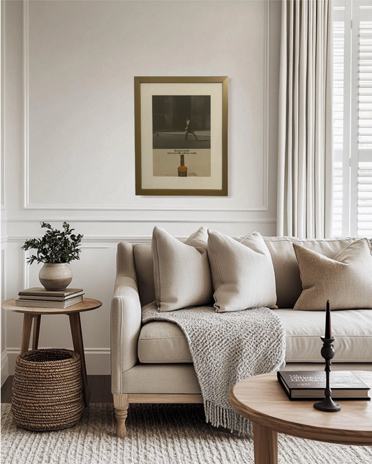 Original Calvert Extra “The Soft Whiskey” vintage advertisement framed in a thin brass frame and displayed on a modern living room wall.