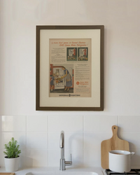 Original 1948 General Electric Space Maker Refrigerator vintage advertisement displayed in a handcrafted brown wood frame on a modern kitchen wall.