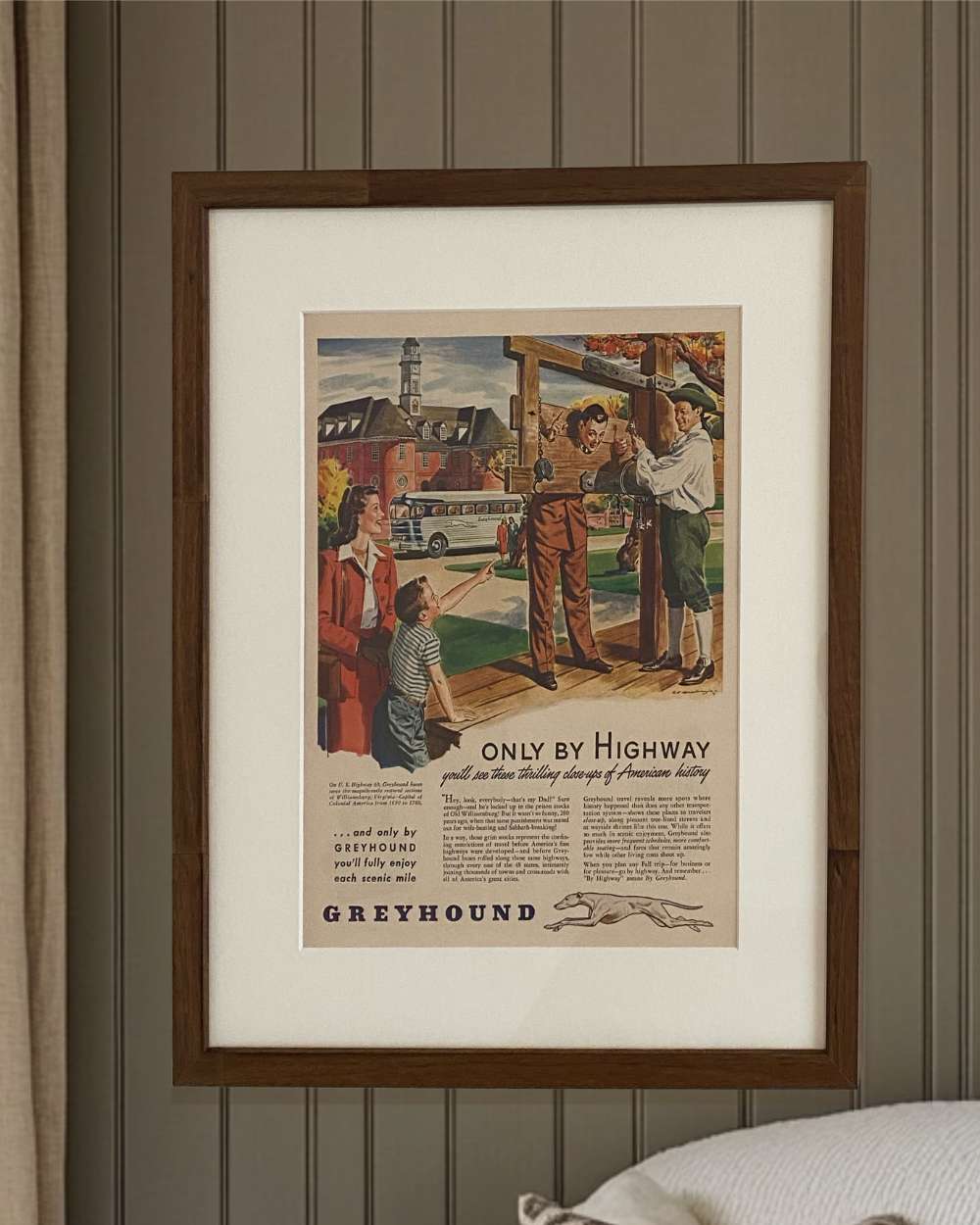 Original Greyhound “Only By Highway” vintage advertisement displayed in a handcrafted brown wood frame on a modern bedroom wall.