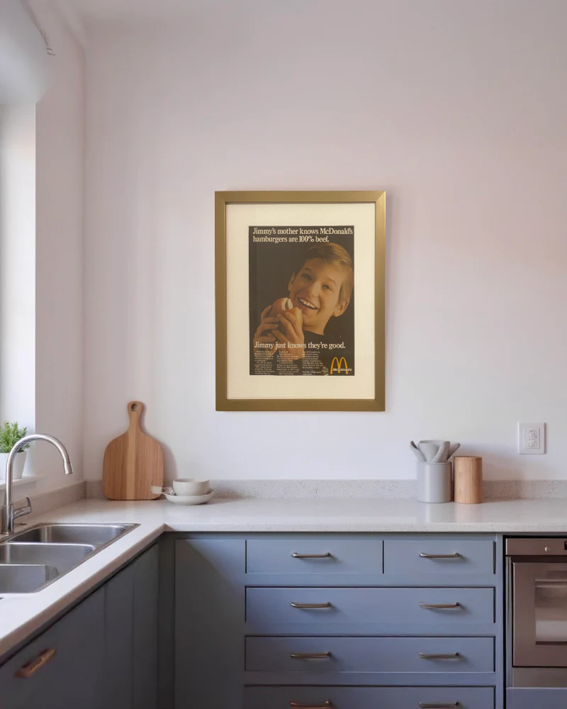 Original McDonald’s “Jimmy’s Mother Knows Hamburgers Are 100% Beef” vintage advertisement framed in brass and displayed on a modern kitchen wall.