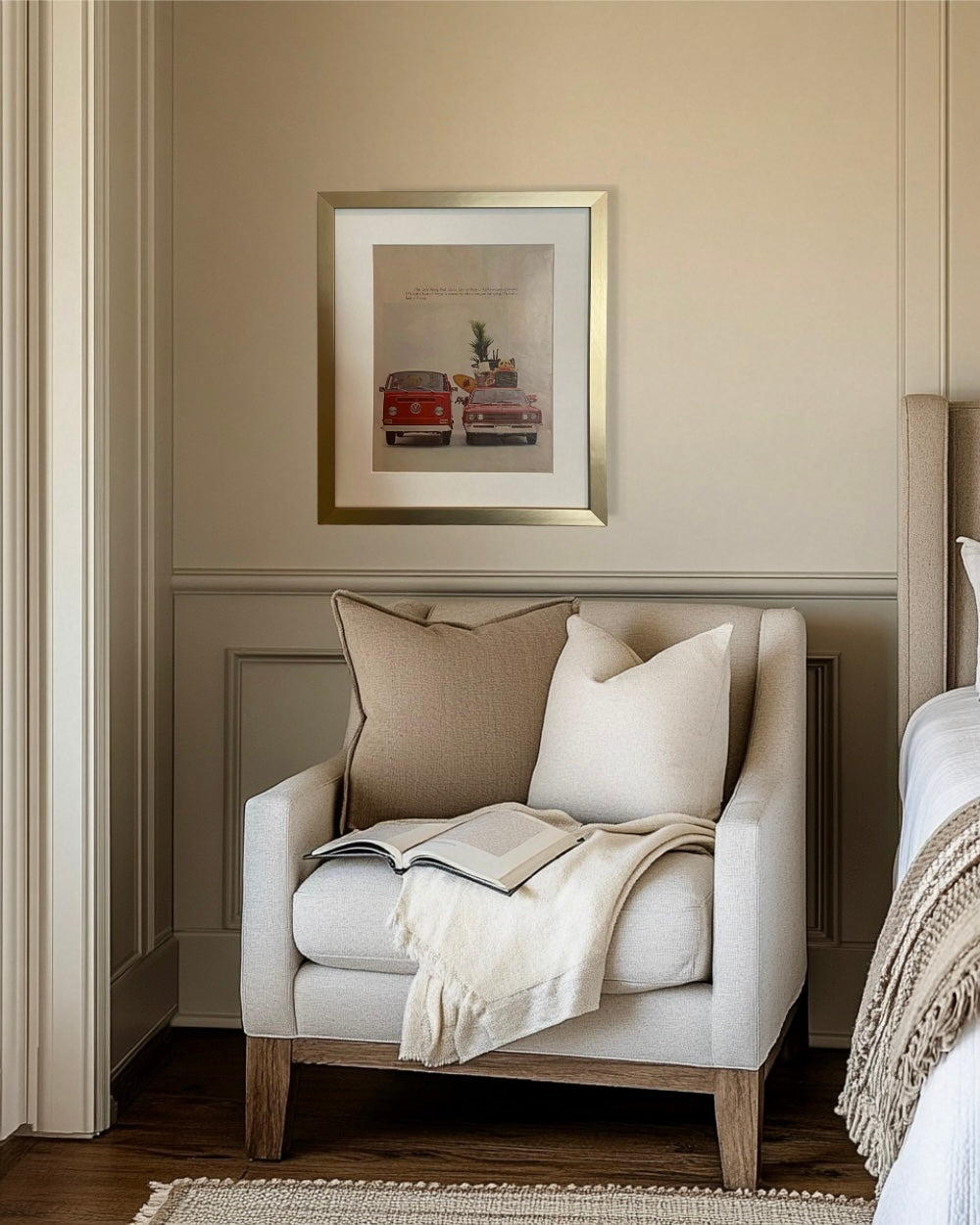 Original vintage Volkswagen advertisement in a brushed brass frame displayed above a neutral bedroom reading nook.