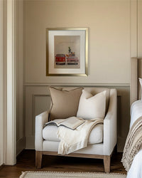 Original vintage Volkswagen advertisement in a brushed brass frame displayed above a neutral bedroom reading nook.
