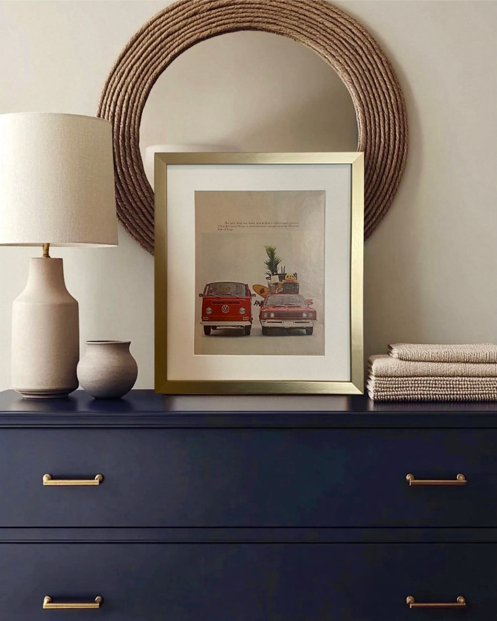 Original vintage Volkswagen advertisement beautifully framed in brushed brass and styled on a dark dresser with warm neutral decor.