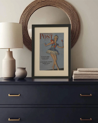 Framed original 1942 Saturday Evening Post ballerina cover displayed on a console table with neutral home decor.