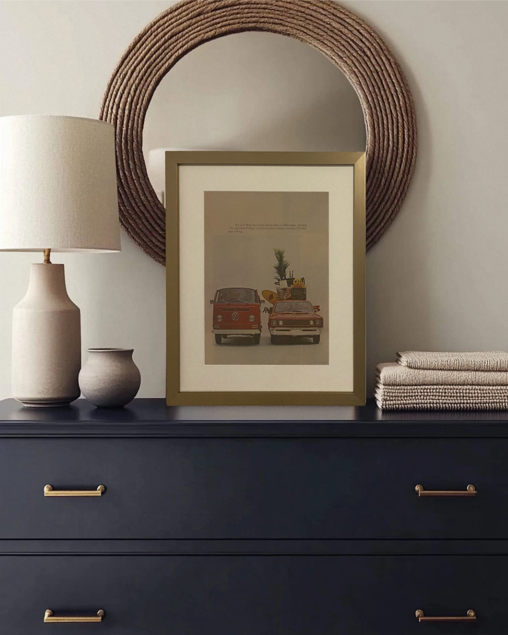 Original vintage Volkswagen “176 Cubic Feet” magazine advertisement professionally framed with an off-white mat, displayed on a modern dresser with brass frame.